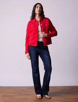 Campera de jean blanca, marca Baccini, con cuello solapa, bolsillos delanteros, abertura central con botones metálicos y terminación desflecada en el ruedo.