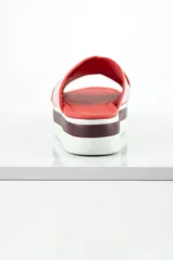Chinelas rojas con plataforma blanca y suela marrón.