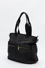 Bolso tote marrón de nylon con doble asa de mano negra y correa bandolera negra regulable y desmontable. Tiene dos bolsillos frontales con cierre metálico dorado.