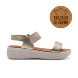 Sandalias de cuero color dorado con plataforma blanca. Presentan dos tiras anchas en el empeine, una de cuero liso y otra elástica acanalada.