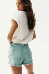 Short de jean color verde agua, de tiro medio, con cinco bolsillos y terminaciones desflecadas.