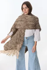 Ruana artesanal tejida en telar con lana hilada a rueca por tejedoras rurales de Uruguay. Diseño con patrón a cuadros en tonos marrón y crudo, con flecos en los extremos.