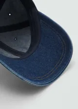 Gorra de jean azul con visera y cierre ajustable en la parte trasera.
