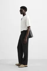 Pantalón negro regular fit confeccionado en tejido de lino. Cintura ajustable con cordón interior, bolsillos frontales y detalle de bolsillos traseros de vivo.