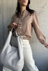 Camisa color beige con bordados florales, cuello mao y mangas largas abullonadas.