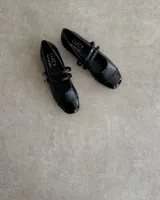 Ballerinas negras de cuero vegano con puntera charolada y doble tira sobre el empeine.