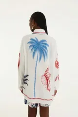 Camisa blanca con estampado de palmeras, peces y la palabra "Brasil" en rojo y azul.