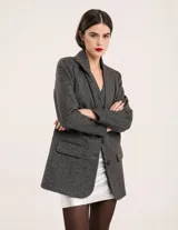 Blazer oversized de casimir 100% lana, de corte recto y largo a la cadera, con cierre delantero de dos botones y hombreras finitas.