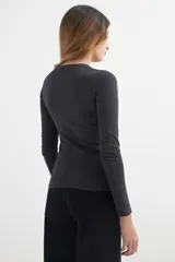 Remera negra de manga larga y cuello redondo.