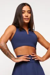 Top deportivo blanco con cuello polo y espalda deportiva. Confeccionado en poliamida y elastano con protección UV50+.
