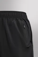 Shorts de entrenamiento color verde claro, confeccionados en tejido técnico ligero y elástico. Sin forro interior, con cintura elástica ajustable con cordón interior, bolsillos frontales y bolsillo trasero de seguridad con cierre de cremallera. Bajo con acabado termofijado y aberturas laterales.