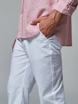 Pantalón color beige de corte regular fit, confeccionado en lino. Cuenta con dos bolsillos frontales y dos bolsillos posteriores, bajo con botamanga y presilla, aplique de badana.