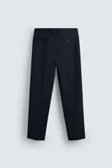 Pantalón de vestir azul marino, de corte recto, con bolsillos laterales y traseros. Se ajusta a la cintura con cinturón de cuero marrón.