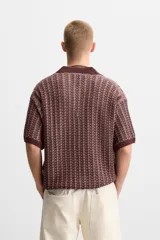 Polo relaxed fit de punto color borgoña con diseño geométrico en beige. Cuello solapa con abertura frontal, manga corta y acabados en rib.