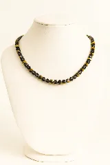 Collar corto de cuentas facetadas en tonos dorados y grises.