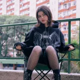Canguro negro con capucha ajustable, corte oversize y doble estampa en el pecho con diseño de gárgolas y letras góticas.