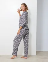 Conjunto de pijama en tejido suave con estampado floral, incluye remera de escote redondo y pantalón con cintura elástica.