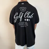 Chomba color beige con cuello clásico, corte oversize, mangas cortas y bordados marrones con la inscripción "Golf Club" y otros motivos. 