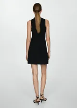Vestido corto evasé color crudo, de tejido de punto fino, sin mangas y con cuello perkins.