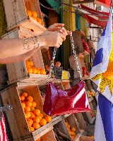 Cartera tipo baguette de cuero color rojo brillante, con correa de cadena plateada.