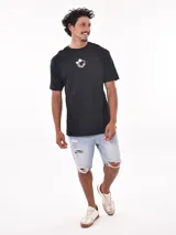 Remera negra de corte oversized con estampado circular en el pecho que incluye una palmera, una ola y la palabra 'Paradise'.