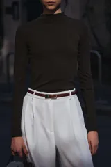 Camiseta blanca de manga larga con cuello alto y corte ajustado.