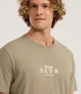 Remera color caqui de algodón con cuello redondo y manga corta. Estampa frontal y trasera con la frase "Larger Beer".
