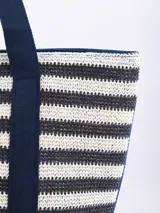 Bolso tipo tote Bali de paja con rayas horizontales negras y beige, con doble asa de hombro negra.