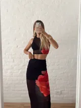 Conjunto de top corto y falda larga de tul negro con estampado de flores rojas.
