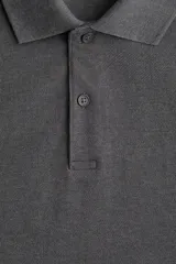 Remera polo gris de piqué de algodón, de manga corta, con cuello clásico, tapeta de botones, remate acanalado en cuello y mangas, bajo recto con aberturas laterales y corte estándar.