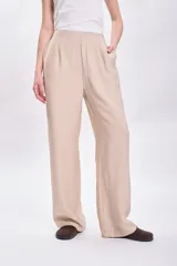 Pantalón de vestir beige de corte palazzo, con cintura alta y bolsillos laterales.