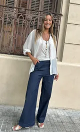 Pantalón de jean de tiro alto, color azul oscuro, de corte ancho y pierna recta. Presenta una pretina ancha y lisa.