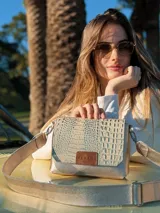 Bandolera dorada de cuero con textura tipo piel de cocodrilo, con correa larga regulable y cierre con solapa y broche imantado.