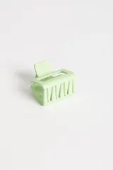 Pinza para el pelo color verde pastel con forma rectangular y diseño geométrico.