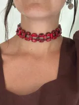 Choker trenzado confeccionado con cuentas de acrílico rectangulares en color rojo. Posee un cierre de mosquetón con cadena de alargue en acero quirúrgico para un ajuste personalizado.