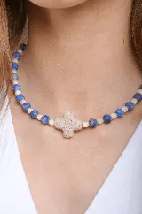 Collar corto con cuentas de piedra natural lapislázuli mate y cristales facetados beige, con dije de cruz de piedra natural y cadena dorada ajustable.