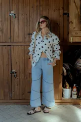 Pantalón de jean celeste de corte ancho, con cintura elástica en la parte trasera y detalles de costuras en los laterales.