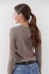 Remera de viscosa color marrón con mangas largas y corte relajado, detalles de puños y cuello a contratono.