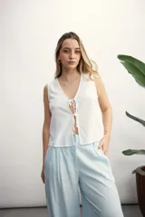 Chaleco blanco con escote en V y lazos frontales.