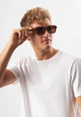 Lentes de sol Eco Shades modelo Romano con montura cuadrada azul traslúcido y lentes grises. Fabricados con acetato biodegradable y lentes de PMMA reciclado.