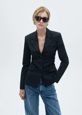 Blazer negro entallado con cuello de pico con solapa, bolsillo de ribete en el pecho, solapas con muesca, diseño recto, detalles fruncidos, dos bolsillos delanteros de ribete y solapa, cierre delantero con botones y forro interior.