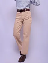 Pantalón de jean color beige, de corte recto y tiro alto, con ruedo desflecado.
