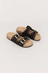 Sandalias negras con dos tiras horizontales con hebillas doradas y ojales metálicos.