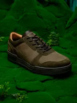 Zapatillas urbanas de cuero color verde oliva con detalles en marrón y negro. Presentan el logo de Star Wars en el talón y el rostro de Yoda grabado en el lateral.