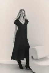 Vestido largo negro de viscosa jacquard, con mangas cortas con detalle de tablas y ojalillos metálicos en mangas y escote.