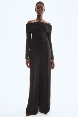 Top negro ajustado de punto elástico con hombros descubiertos, mangas largas, escote ancho con doblez y laterales fruncidos.