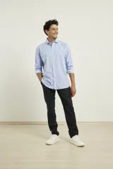Camisa de vestir color celeste con corte clásico y botones frontales.