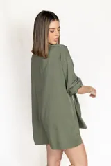 Camisa negra de corte amplio, con mangas largas y puños abotonados.