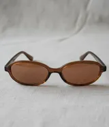 Lentes de sol con montura ovalada de acetato color marrón translúcido (tortoise/carey) y lentes degradados color marrón.