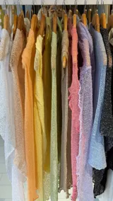 Poncho tejido de punto calado, disponible en varios colores pastel.